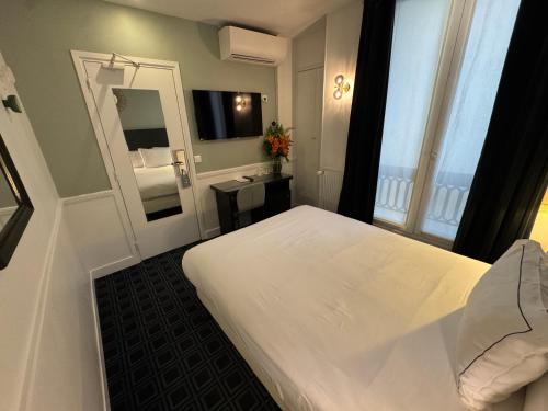 a hotel room with a white bed and a mirror at Hôtel Etoile Trocadéro in Paris