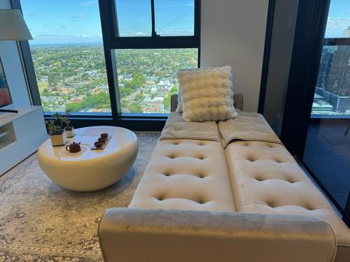 a living room with a couch and a coffee table at Box Hill luxury 29th floor apartment with car park in Box Hill