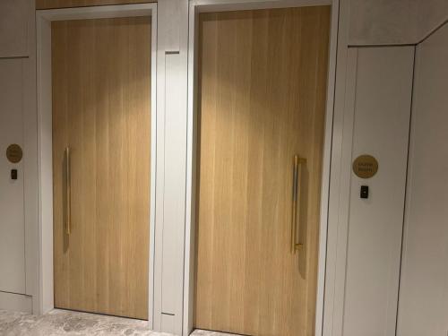 two wooden doors in a room next to each other at Box Hill luxury 29th floor apartment with car park in Box Hill