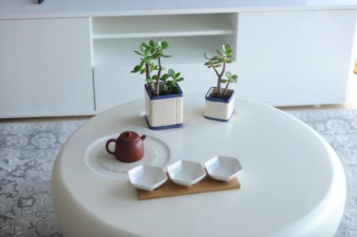 a white table with three plants on top of it at Box Hill luxury 29th floor apartment with car park in Box Hill