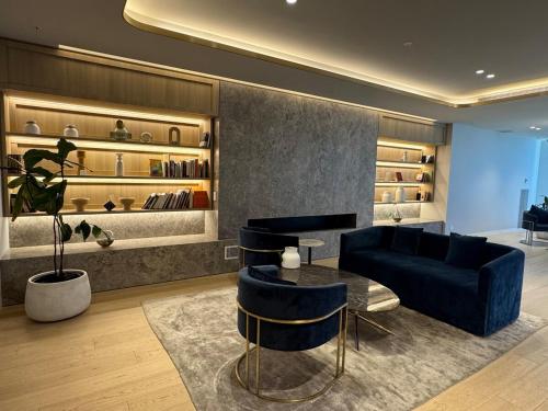 a living room with a blue couch and a table at Box Hill luxury 29th floor apartment with car park in Box Hill