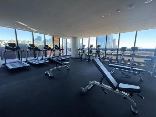a gym with a row of treadmills and machines at Box Hill luxury 29th floor apartment with car park in Box Hill