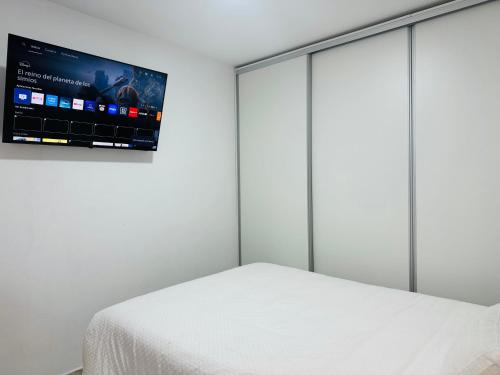 a bedroom with a bed and a flat screen tv at Apartamento Noori 1B in Vinaròs
