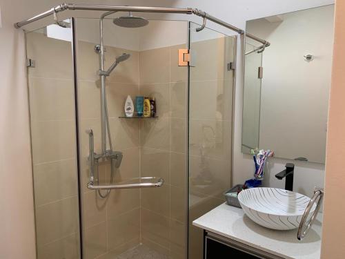 a bathroom with a glass shower with a sink at LuxNar Beach GF in La Gaulette