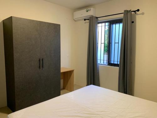 a bedroom with a large cabinet and a window at LuxNar Beach GF in La Gaulette