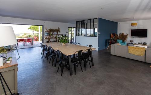 un grand salon avec une table et des chaises dans l'établissement Villa 180 Mer La Rochelle Ile de Ré, à LʼHoumeau