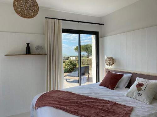 une chambre avec un lit et une porte coulissante en verre dans l'établissement Villa 180 Mer La Rochelle Ile de Ré, à LʼHoumeau