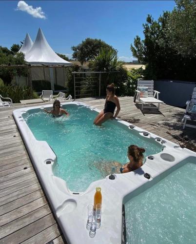 un groupe de personnes dans un jacuzzi dans une piscine dans l'établissement Villa 180 Mer La Rochelle Ile de Ré, à LʼHoumeau