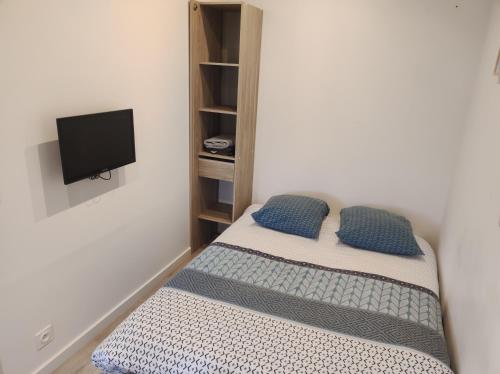 a small bedroom with a bed and a tv at Dépendance cosy in Longages