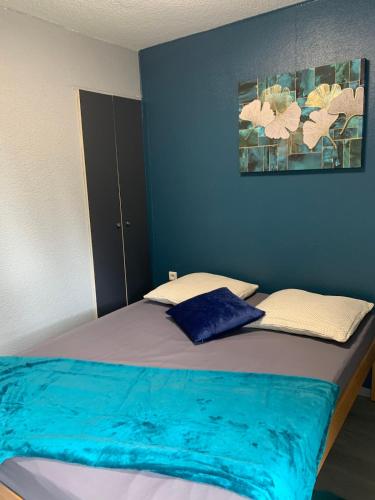 une chambre avec un lit aux murs bleus dans l'établissement Cottage entier 4 ou 6 personnes gîte 19, à Signy-le-Petit