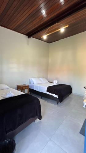 a bedroom with two beds and a wooden ceiling at Pousada Emerências dos Búzios in Armacao dos Buzios