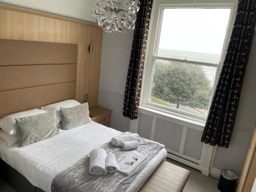 a bedroom with a bed with towels on it at The Wildings Hotel & Tudno's Restaurant in Llandudno