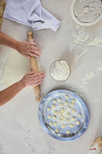 a person kneading dough next to a plate of food at Relais Corte Palmieri & Il Chiostro - Residenza d'epoca in Gallipoli
