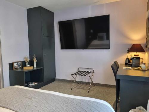 a bedroom with a bed and a desk and a tv at Logis Hotel Schaeffer- Restaurant Le Saint Georges in Serrières