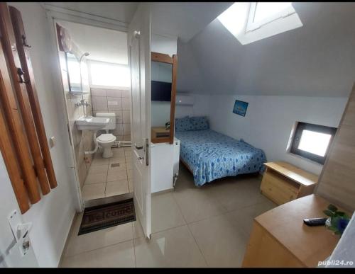 a small bathroom with a bed and a sink at Vila Masy in Costinesti