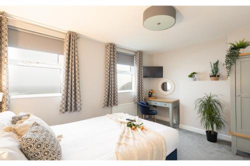 a bedroom with a bed and a desk and a window at The Clarence Gardens Hotel, BW Signature Collection in Scarborough