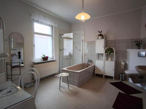 a bathroom with a tub and a sink at FeWo Wittstock in Wittstock