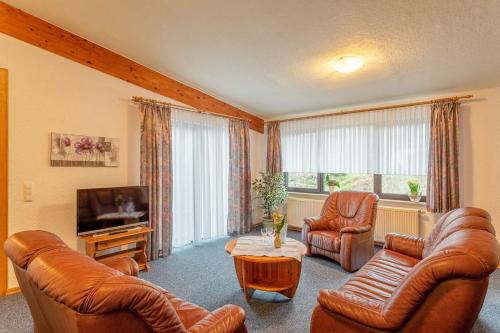 a living room with leather furniture and a television at Hotel Restaurant Zur Neroburg in Neroth