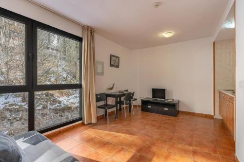 ein Wohnzimmer mit einem Schreibtisch und einem Tisch mit Stühlen in der Unterkunft Monte Gorbea Mumu 7 I in Sierra Nevada