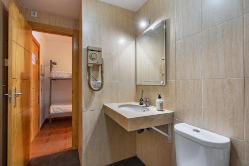 Un baño con lavabo, inodoro y espejo. en Monte Gorbea Mumu 7 I, en Sierra Nevada