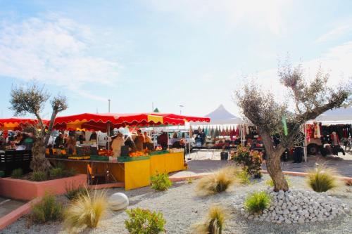 un mercato agricolo con persone in piedi in un parcheggio di M T2 climatisé à100m de la plage ,des bateaux ,des commerces, Une terrasse ensoleillée a Palavas-les-Flots