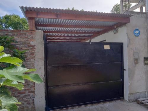 una puerta de garaje negra con techo de metal en Casa Madre City Bell, en City Bell