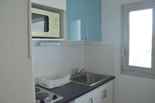 une cuisine avec un évier et un micro-ondes dans l'établissement Studio CAP D 'AGDE CT150-D210, au Cap d'Agde
