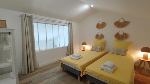 - une chambre avec un lit jaune et une grande fenêtre dans l'établissement Petit Sablé - T3 avec Terrasse Proche Cassis, à Roquefort-la-Bédoule