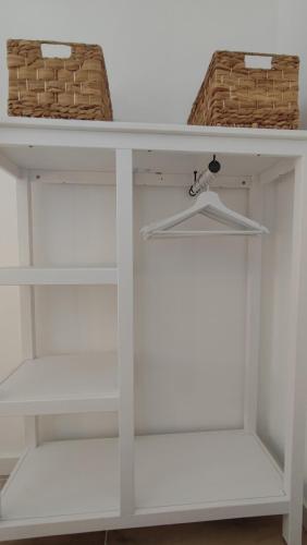 une étagère blanche avec deux paniers dessus dans l'établissement Petit Sablé - T3 avec Terrasse Proche Cassis, à Roquefort-la-Bédoule