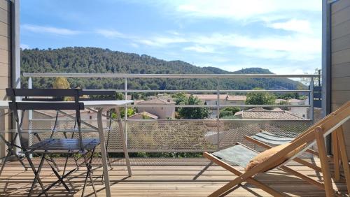 a patio with a table and chairs on a balcony at Petit Sablé - T3 avec Terrasse Proche Cassis in Roquefort-la-Bédoule