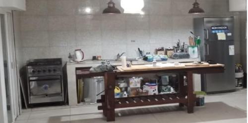 Una cocina con encimera con estufa y refrigerador. en Casa Madre City Bell, en City Bell