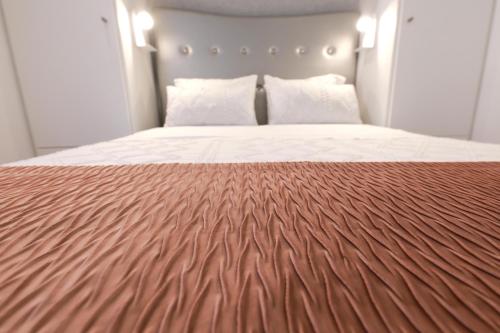 a bedroom with a large bed with a brown blanket at Guest House Abegorias Nazaré in Nazaré