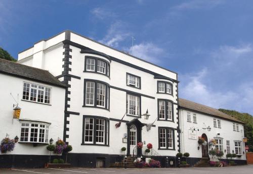 a white building with black windows and flowers at Donington Manor Hotel in Castle Donington
