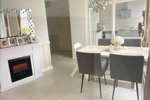 een eetkamer met een open haard en een tafel en stoelen bij Private Apartment in Hannover