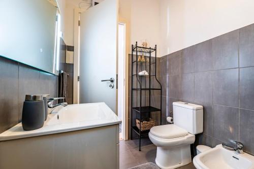 a bathroom with a white toilet and a sink at Casa da Foz in Porto