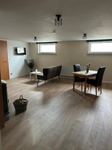 a living room with a table and chairs and a tv at Chez Nadia in Leutenheim
