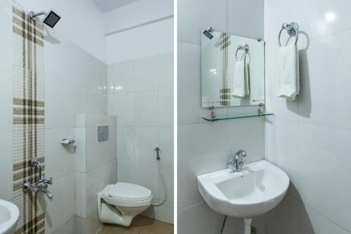 a white bathroom with a sink and a toilet at Hotel O Manjulam Regency in Indore