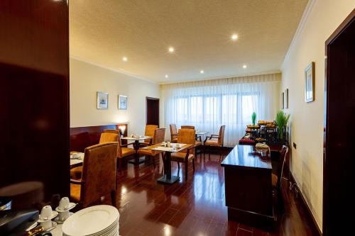 a living room with tables and chairs and a dining room at Lancaster Kumasi City in Kumasi
