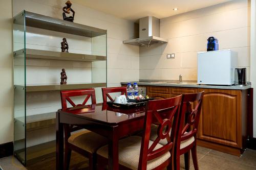a kitchen with a wooden table and red chairs at Lancaster Kumasi City in Kumasi