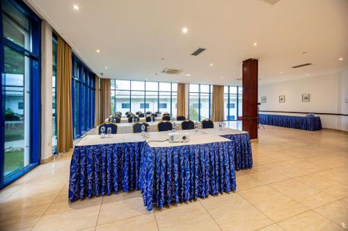 a meeting room with a long table with blue skirts at Lancaster Kumasi City in Kumasi