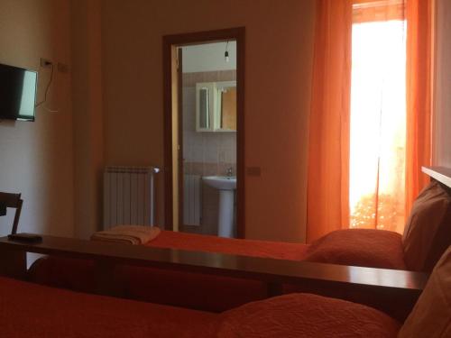 a bedroom with a bed and a sink and a mirror at Albergo BELVEDERE in Santa Cristina Gela