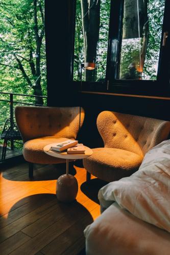 two chairs and a table in a room with a window at Loop - K1 Treehouses in Odenthal