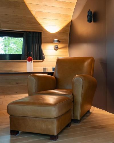 a living room with a chair and a stool at Loop - K1 Treehouses in Odenthal