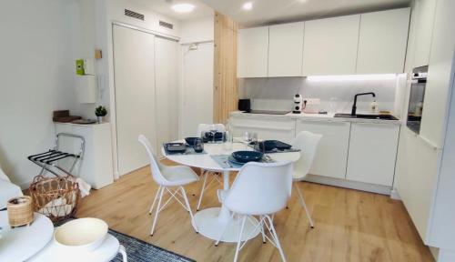 a kitchen with a white table and white chairs at Quartier de la plage in Roquebrune-Cap-Martin