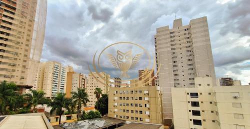 a tall building with a symbol on it in a city at Coruja Imob - Flat Crystal Place in Goiânia