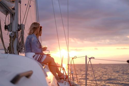 a woman sitting on a boat watching the sunset at Anore Luxury Suites in Nikiti