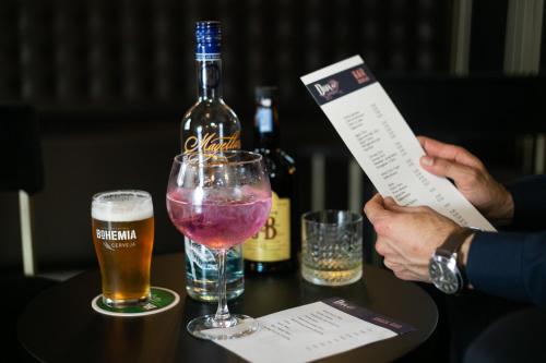 una persona sosteniendo un pedazo de papel junto a una botella de cerveza en Casual Inca Porto, en Oporto