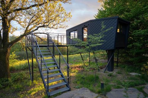 a tree house with a staircase leading up to it at Oak - K1 Baumhaus in Odenthal