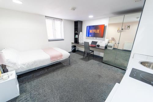 a bedroom with a bed and a desk and a tv at 24 Dale Road Studios in Birmingham