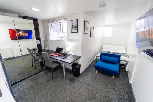 a room with a desk and a bed and a desk and chairs at 24 Dale Road Studios in Birmingham